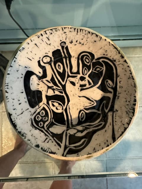 Handcrafted ceramic bowl with a striking black and white abstract pattern and textured rim.