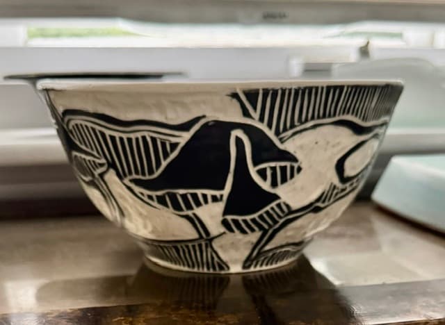 Black and white ceramic bowl featuring abstract mushroom motifs and intricate vertical line patterns.