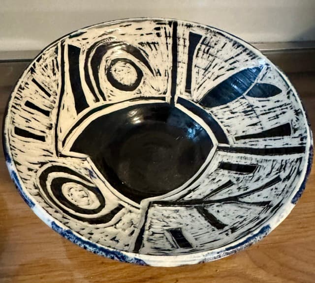 Abstract black and white ceramic bowl with bold graphic patterns and a deep black center.