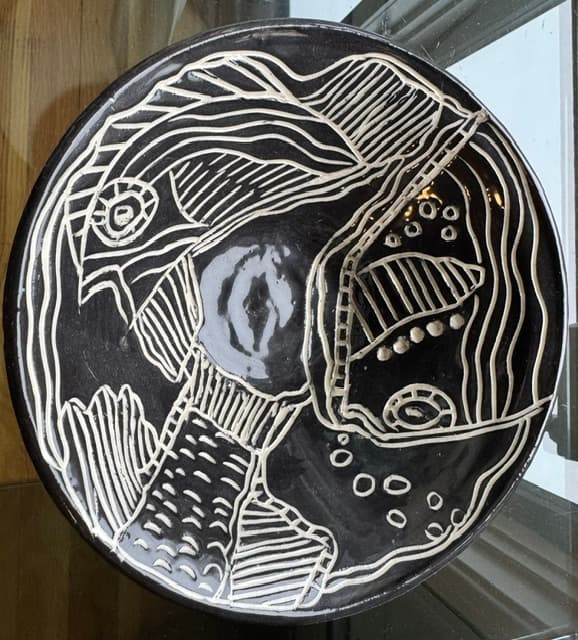 Round black ceramic plate featuring intricate abstract white line art and various textured geometric patterns.