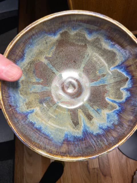 Ceramic bowl with a striking blue and brown glaze pattern radiating from the center.